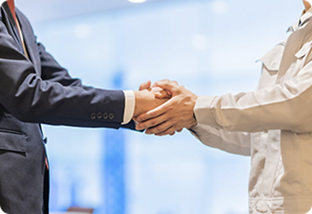 握手を交わすビジネスマンと外国人スタッフ