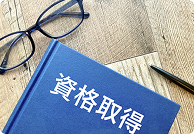 資格取得を示すノートとペン